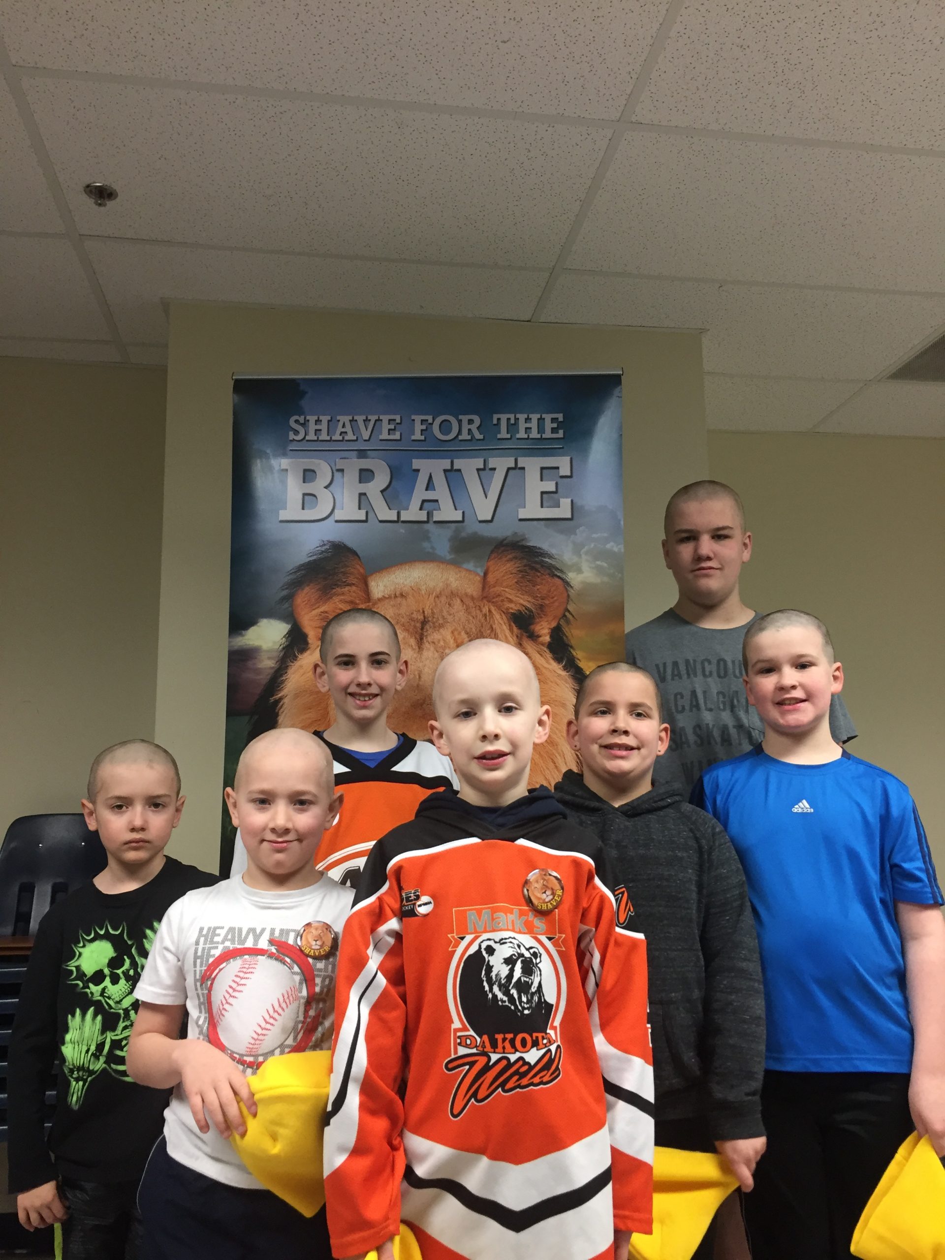 7 mount pearl blades players posing after getting their heads shaved.
