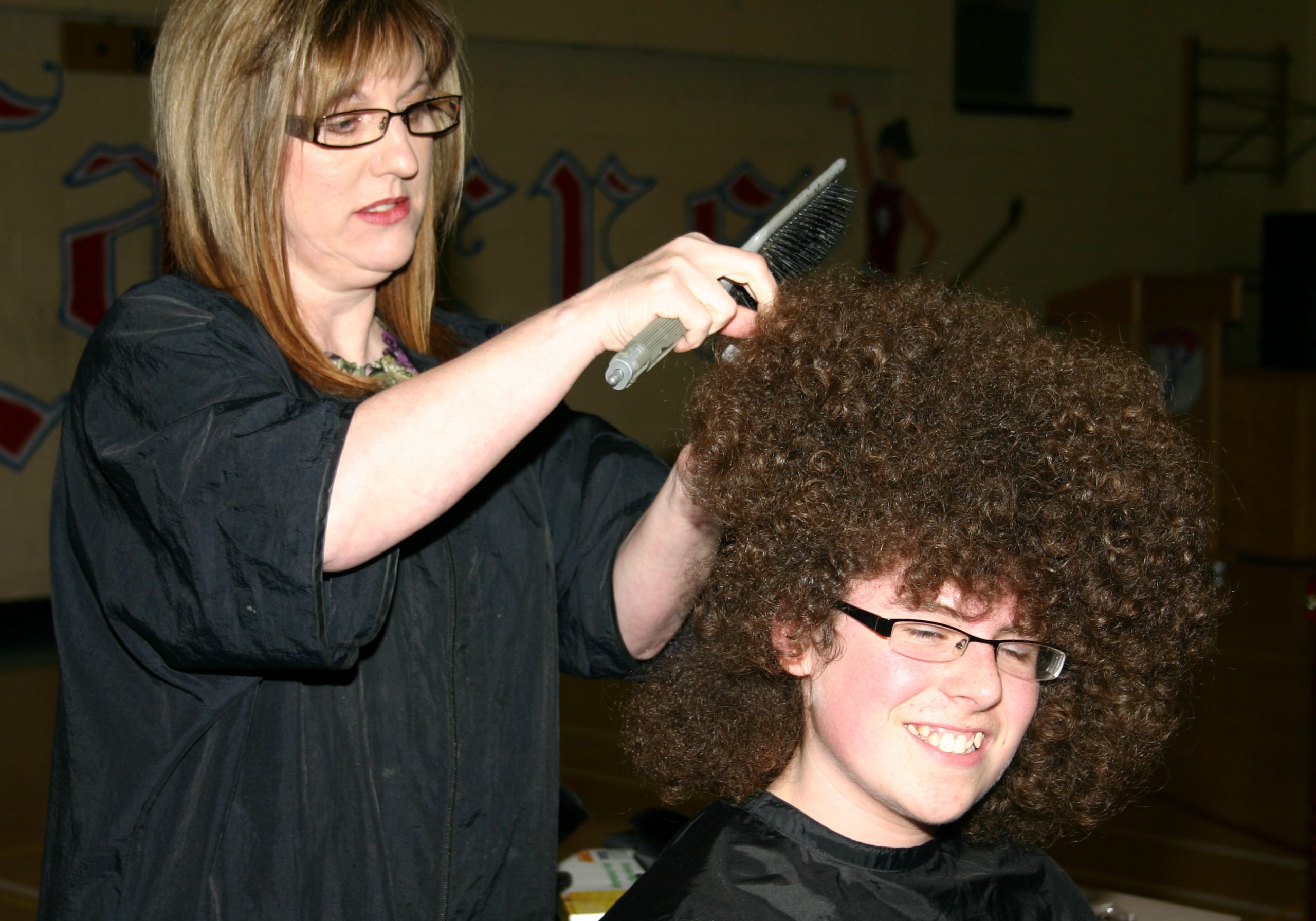 Mackenzie Bingle and a woman inspecting his hair before his shave