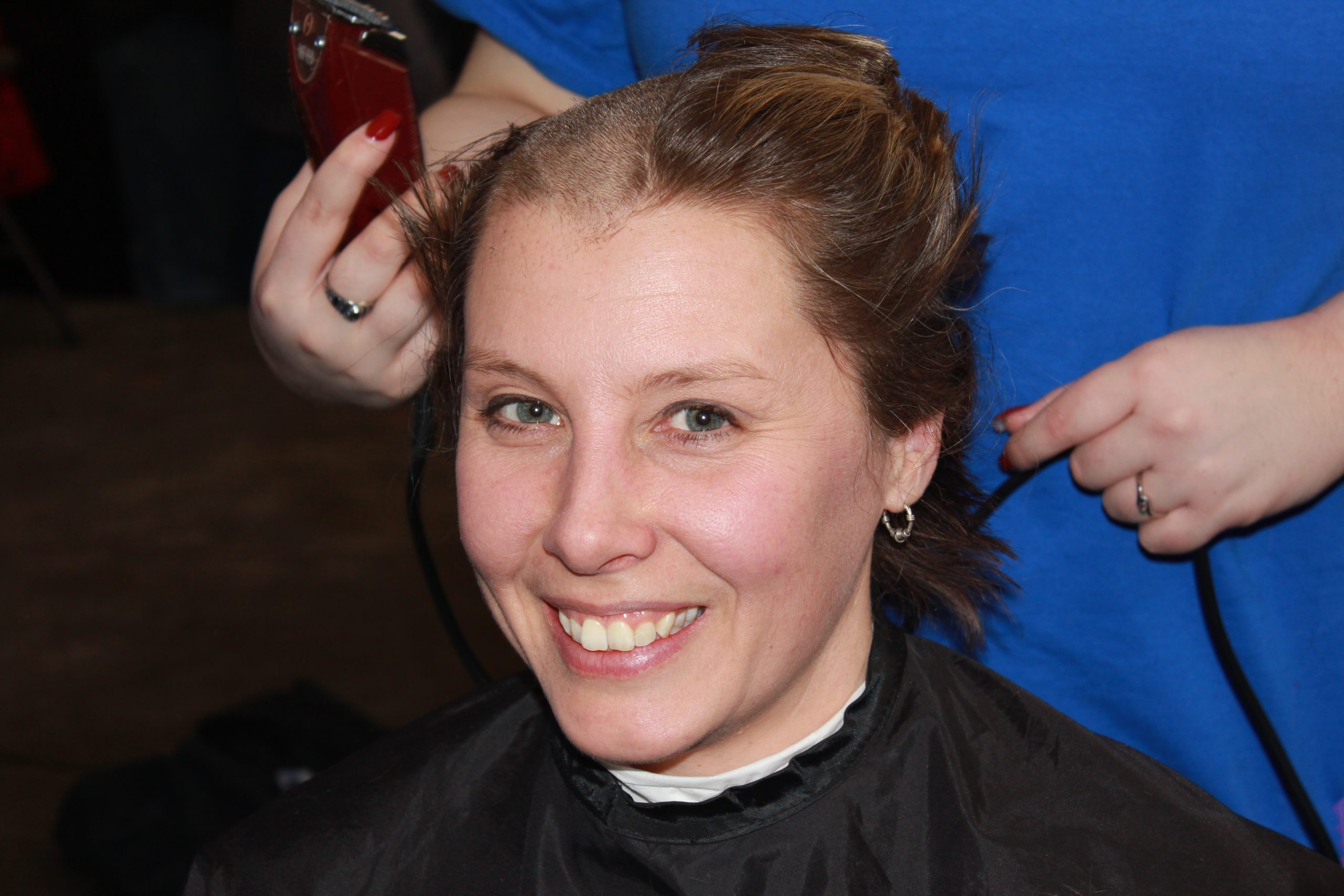 Titia Praamsma with a smile on her face in the midst of getting her head shaved