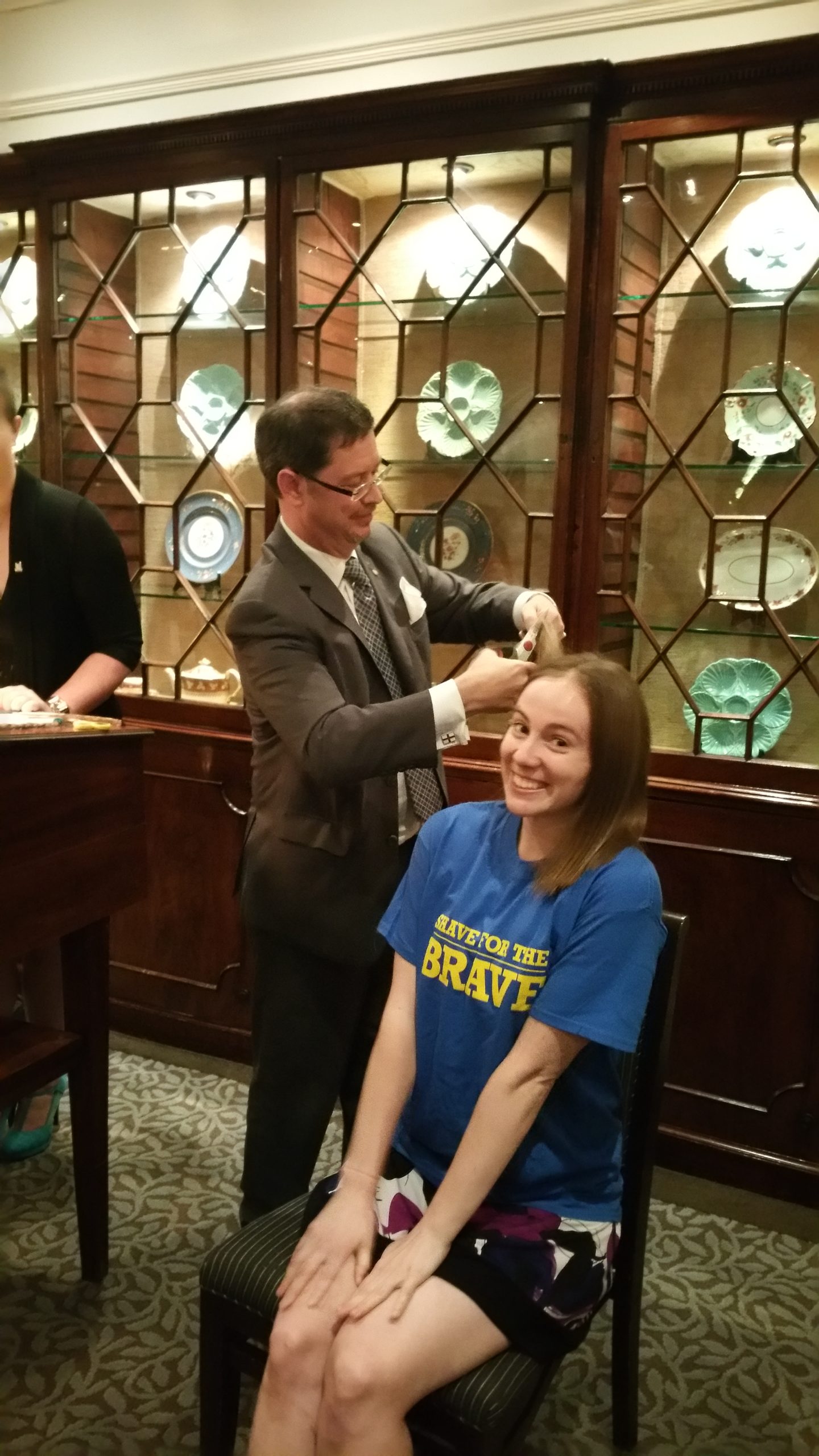 Jessica Besaw sitting down and smiling, about to get her hair cut.