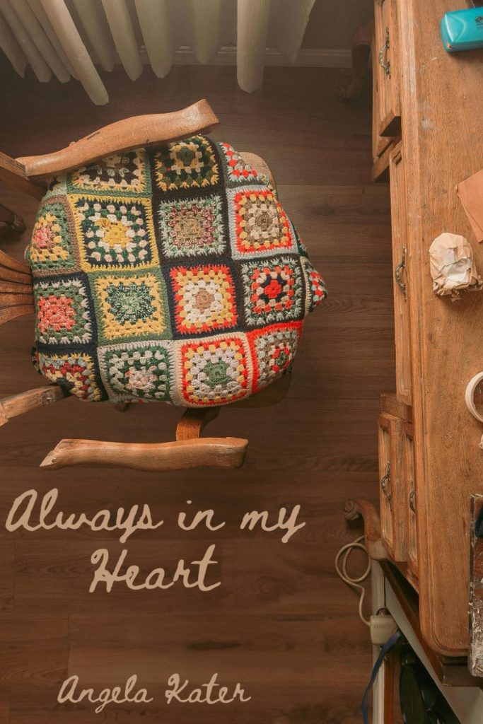 The cover image of "Always In My Heart," Angela Kater's book that Stephanie finished for her. It is an aerial shot of a desk and chair. There is a crocheted blanket on the seat of the chair.